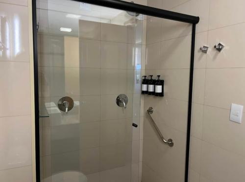 La salle de bains est pourvue d'une douche avec une porte en verre. dans l'établissement QS Marista - Studio Alessandra Antonelli - Flat 1708, à Goiânia