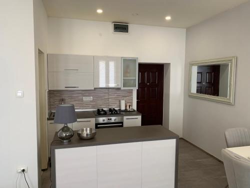 a kitchen with white cabinets and a stove top oven at Zara City Apartments in Zadar