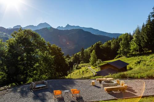 a house on a hill with chairs and a couch at Grand chalet convivial avec sa piscine intérieure in Serraval