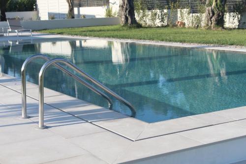 a swimming pool with a metal hand rail next to it at Stablo Residence in Kanálion