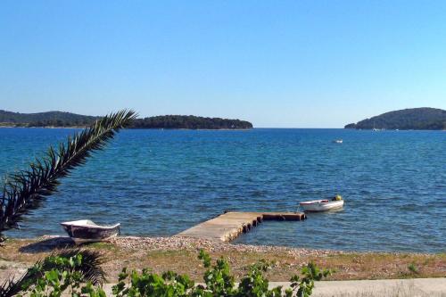 ein Dock mit zwei Booten auf einem großen Wasserkörper in der Unterkunft Apartments by the sea Krapanj, Sibenik - 9258 in Brodarica