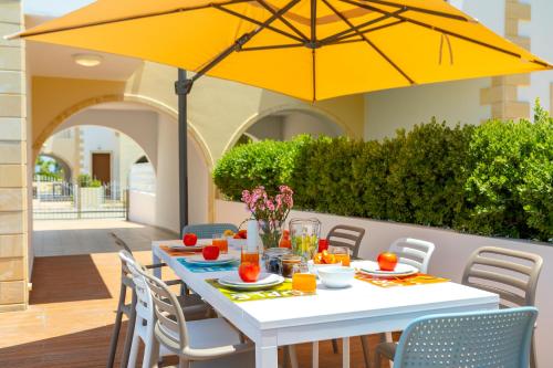 a table with a yellow umbrella on a patio at Villa Lantos Central Protaras in Protaras