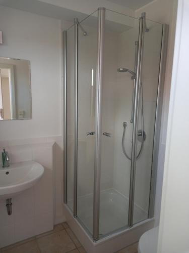a shower with a glass door in a bathroom at Bi Grete vörn in Dornum