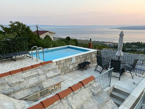 eine Terrasse mit einem Pool, einem Tisch und Stühlen in der Unterkunft Villa Kristina - Ferienhaus Baška Voda - Topići, Private Outdoor Swimmingpool, WiFi in Baška Voda