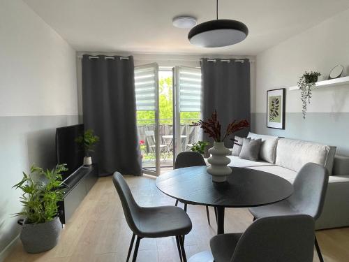 a living room with a couch and a table and chairs at Przestronne apartamenty na Mazurach in Węgorzewo