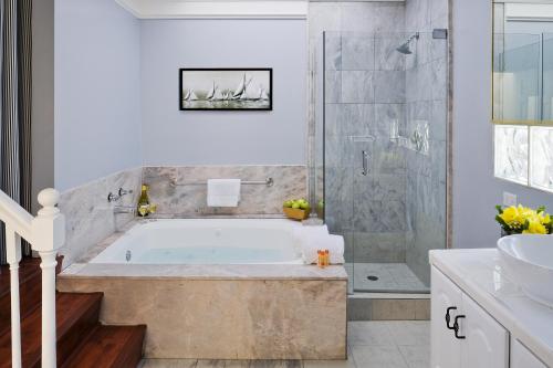 a bathroom with a tub and a shower and a sink at Newport Beach Hotel in Newport Beach