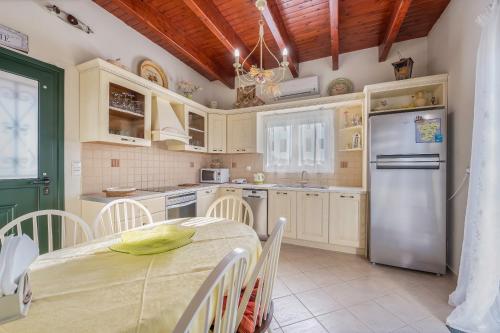 uma cozinha com uma mesa e um frigorífico em MARFAIA - Villa by the sea em Áyioi