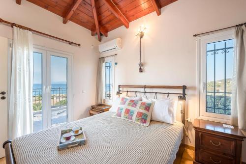 um quarto com uma cama e vista para o oceano em MARFAIA - Villa by the sea em Áyioi