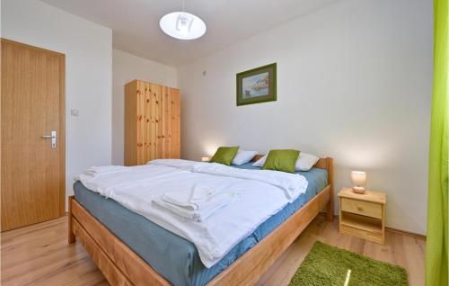 ein Schlafzimmer mit einem großen Bett mit weißer Bettwäsche und grünen Kissen in der Unterkunft Beautiful Home In Globocec Ludbrecki With Heated Swimming Pool in Čukovec