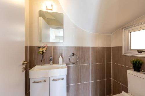 a bathroom with a sink and a mirror at Villa Lantos Central Protaras in Protaras