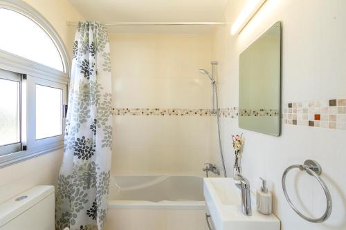 a bathroom with a shower curtain and a sink at Villa Lantos Central Protaras in Protaras