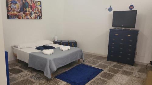 una camera con letto e TV a schermo piatto di Baglio San Basilio a Palermo