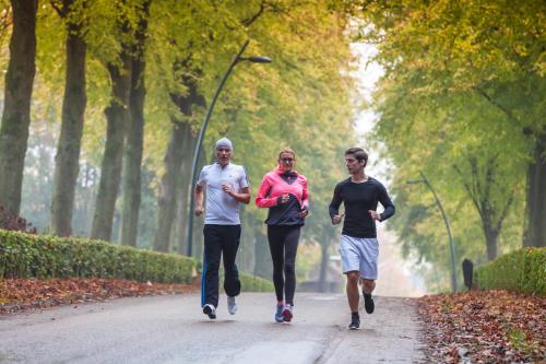 three people running down a road in a park at Van der Valk Hotel Heerlen in Heerlen