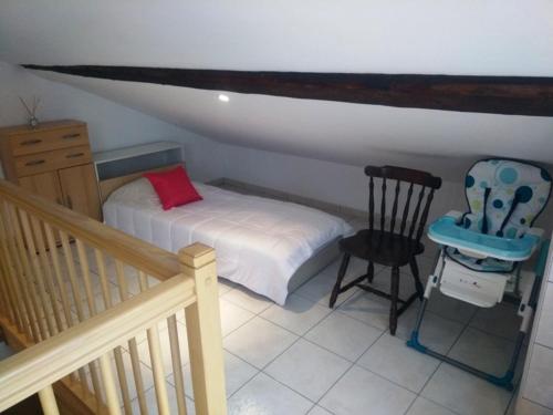 um pequeno quarto com uma cama e uma cadeira em Appartement en location touristique pour 4 personnes em Docelles