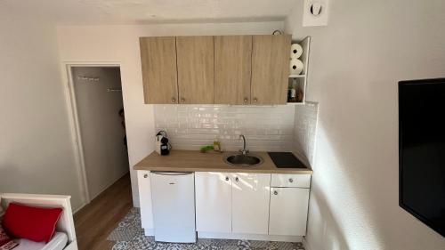 a small kitchen with white cabinets and a sink at la foux d'allos au pied des pistes in La Foux