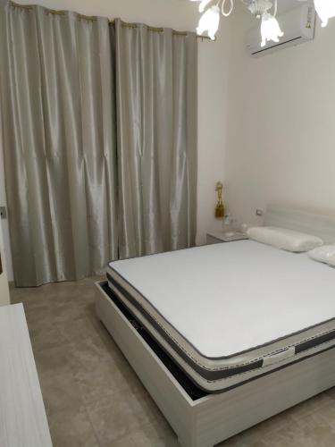 1 cama blanca en un dormitorio junto a una ventana en Villa Aurora 1, en Torre Lapillo