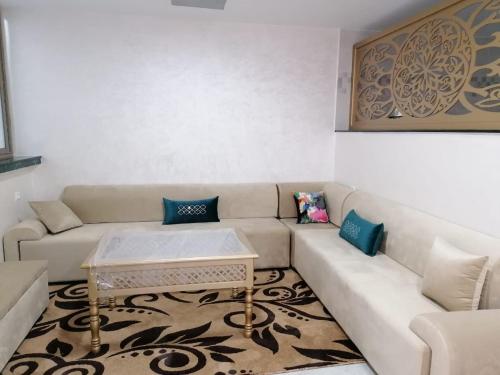 a living room with a couch and a coffee table at Hébergement lux dakhla in Dakhla