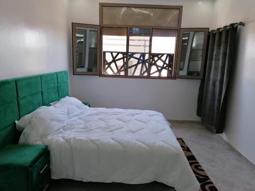 a bedroom with a large bed and a window at Hébergement lux dakhla in Dakhla