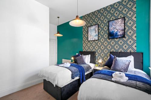 sypialnia z 2 łóżkami i zieloną ścianą w obiekcie Stunning Abode - Sleeps 10 - Parking w Bristolu