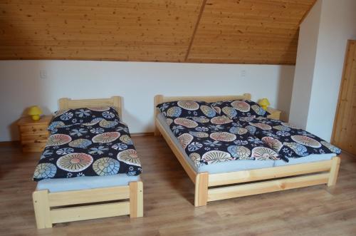 two beds sitting next to each other in a room at Chalupa Mezi rybníky in Frahelž