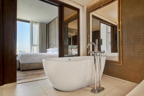 a bathroom with a bath tub and a bedroom at Crowne Plaza - West Cairo Arkan, an IHG Hotel in 6th Of October