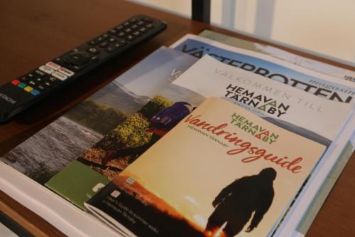 a book sitting on a table next to a remote control at Hemavans Wärdshus in Hemavan