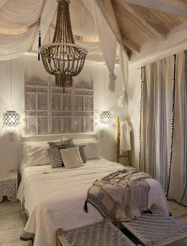 Un dormitorio con una cama grande y una lámpara de araña. en Linari Bohemian Living, en Kávallos