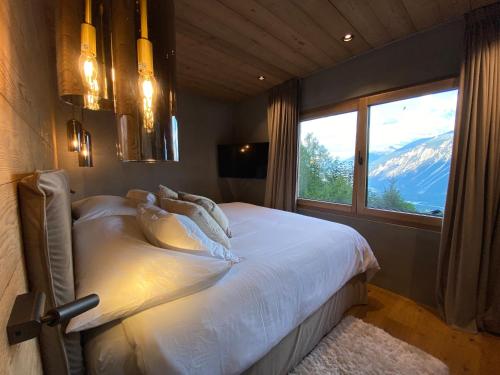 a bedroom with a bed with a view of a mountain at Chalet 7 Luxury Chalet with Cinema room in Crans-Montana