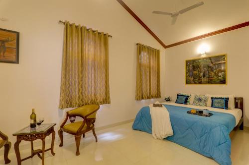 a bedroom with a bed and a table and a chair at Ludo Private Pool Villa, WiFi-Caretaker-Parking, North Goa in Baga