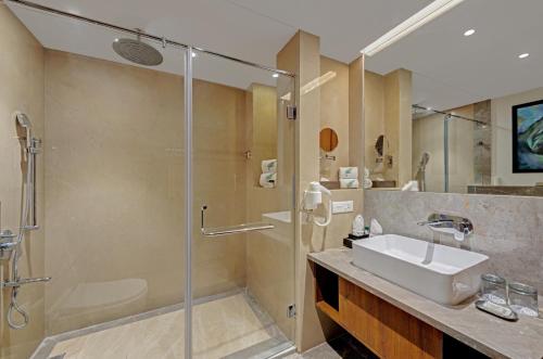 a bathroom with a glass shower and a sink at The Fern Leo Resort & Club - Junagadh, Gujarat in Junagadh