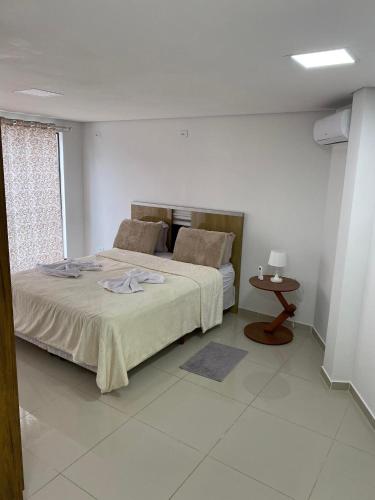 um quarto com uma cama grande e uma mesa em Hospedaria Maviane Executive em Treze Tílias