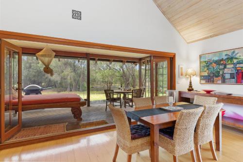 a living room with a dining table and a bedroom at Yallingup Retreat - Romantic Country Retreat for Couples in Yallingup