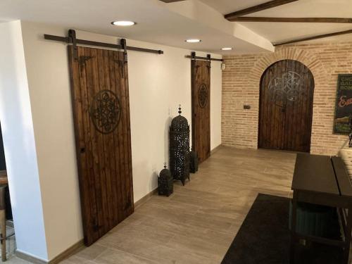 a hallway with wooden doors and a room with a skateboard at La Amapola in Valdemorillo