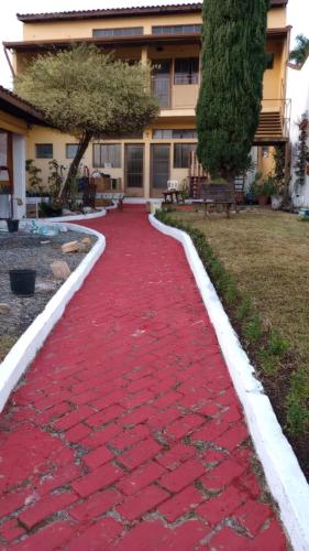 a red carpet path in front of a building at Hospedagem Santa Gertrudes Comensoli in Cachoeira Paulista