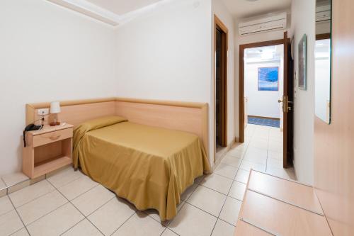 a bedroom with a bed with a yellow bedspread at Hotel Garni Losanna in Bibione