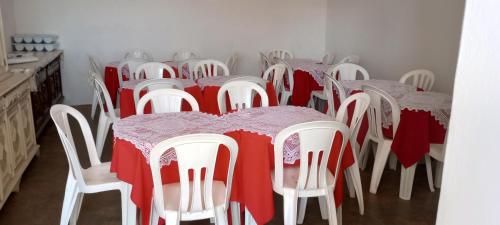 a group of tables and chairs with red and white table cloth at Hospedagem Santa Gertrudes Comensoli in Cachoeira Paulista
