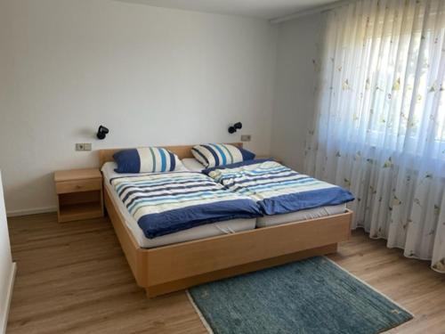 a bedroom with a bed with blue and white sheets at Gästehaus Murgtalblick in Gernsbach