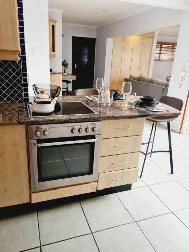 cocina con fogones y mesa con copas de vino en Finna's lovely 1-bedroom open plan vacation home. en Germiston