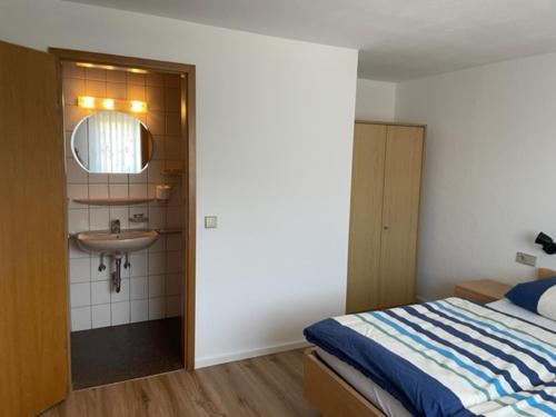 a bedroom with a bed and a sink at Gästehaus Murgtalblick in Gernsbach