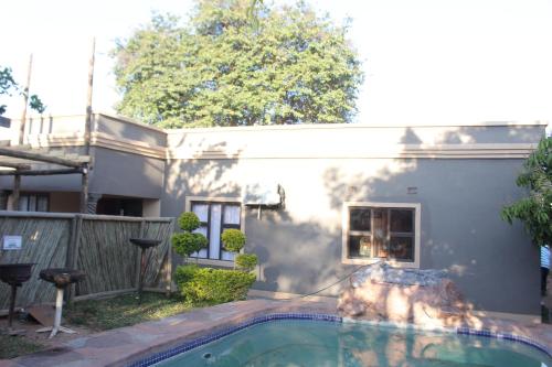 a house with a swimming pool in the yard at Global Guest House in Kasane