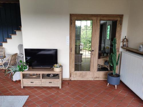 a living room with a flat screen tv and a door at Villa Viveye in Ferrières