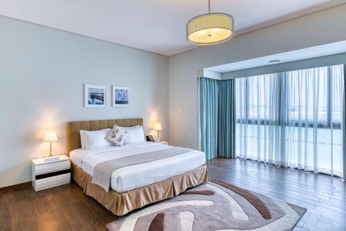 a bedroom with a large bed and a large window at The Grove Resort Bahrain in Manama
