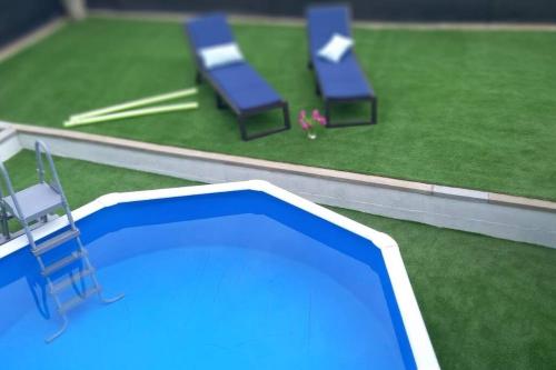 une piscine entourée de chaises et d'herbe dans l'établissement Casa Joana, à Canyelles