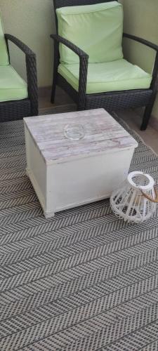 a white coffee table sitting on a rug with two chairs at Apartman Dane in Duće
