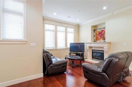 a living room with two chairs and a fireplace at Imperial House in Burnaby