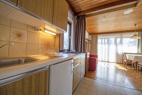 a kitchen with a sink and a table in a room at Apartments Praruf in Selva di Val Gardena