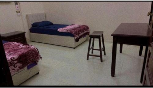 a room with two beds and a table and a desk at Hostel 35 in Medina