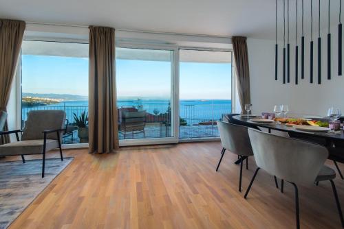 een eetkamer met een tafel en uitzicht op de oceaan bij Premium apartment with beautiful sea view, short walk to the sea in Opatija