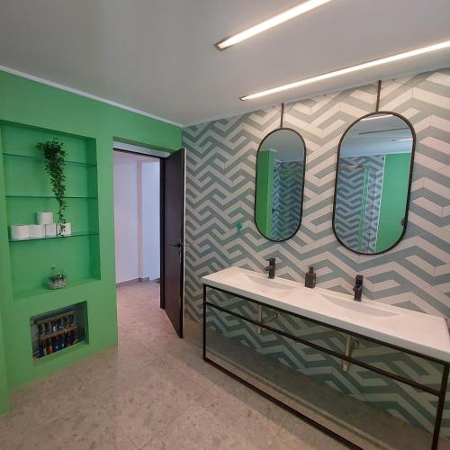 łazienka z dwiema umywalkami i dwoma lustrami w obiekcie BEDWAVE Seaside Mansion w Pireusie
