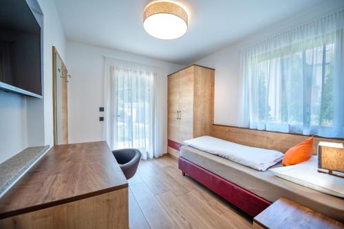 a bedroom with a bed and a large window at Apartments Cesa Ploner in Ortisei